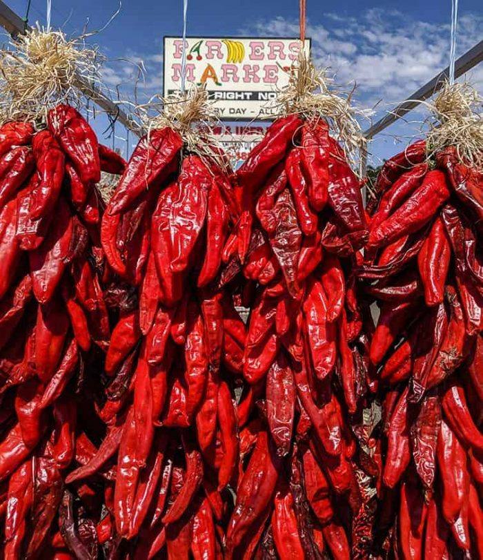 Hatch chile ristras hanging up in front of old sign at Farmers Chile Market 