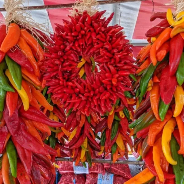 a Hatch pequin chile wreath in between two multicolored Hatch chile ristras