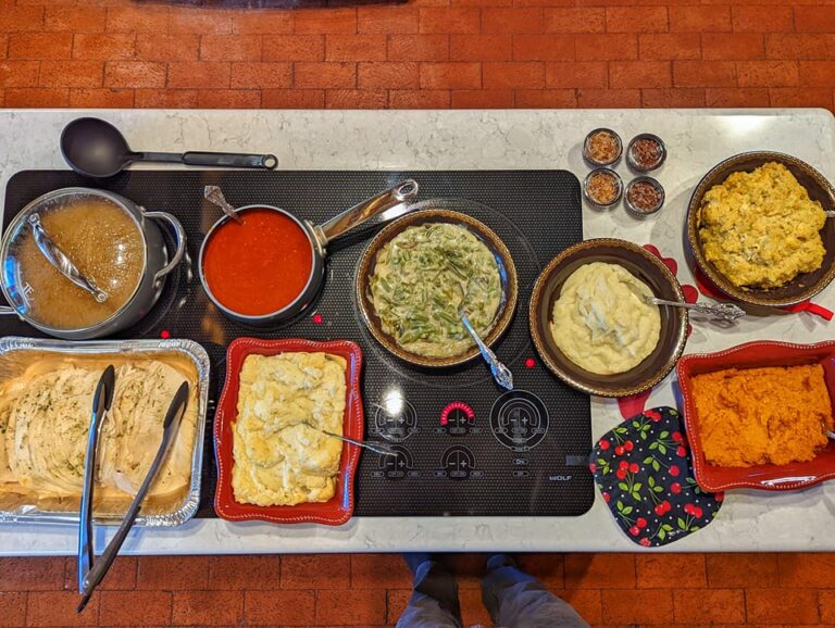 Many different foods at a thanksgiving dinner in New Mexico, including red and green chile sauces