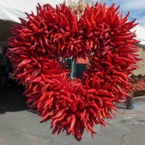 A chile ristra made into the shape of a heart with chile pequin